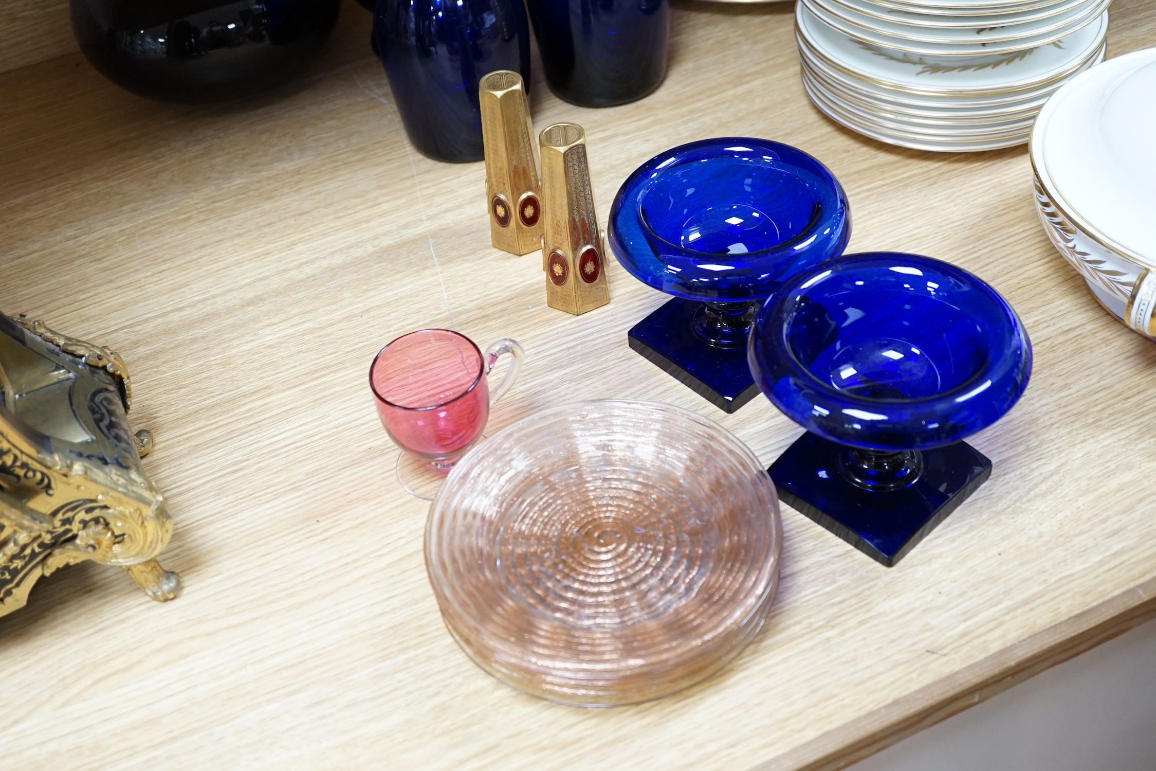 A collection of Bristol blue glassware and other coloured glass including two blue glass decanters, a cranberry, cut glass, decanter, three jugs, pedestal bowls, plates, a pair of miniature vases, etc., tallest 39.5cm (2